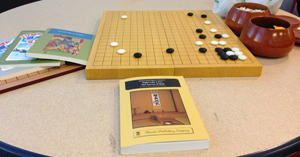 For those curious ones, the books are Fight Like a Pro, Jump Level Up 2 + Answer Book, and Get Strong at Joseki 3, and the set I'm using is a portable shin-kaya board with biconvex yunzi stones in kitani bowls.